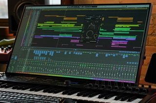 A close-up horizontal perspective of a professional audio mixing console and studio speakers glowing inside a dark music studio, explaining free for profit beats meaning