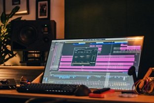 A computer monitor displaying vocal audio waveforms and audio plugins inside a digital audio workstation.