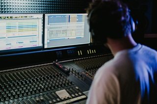 Audio engineer working at a mixing console in a recording studio