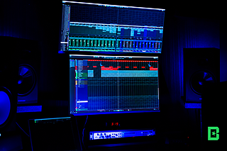 Digital audio workstation DAW screen displaying multitrack audio stems and colored waveforms for a beat project.