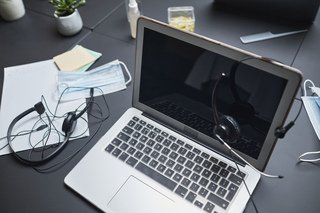 Laptop and headphones on a desk used for browsing and listening to music online.